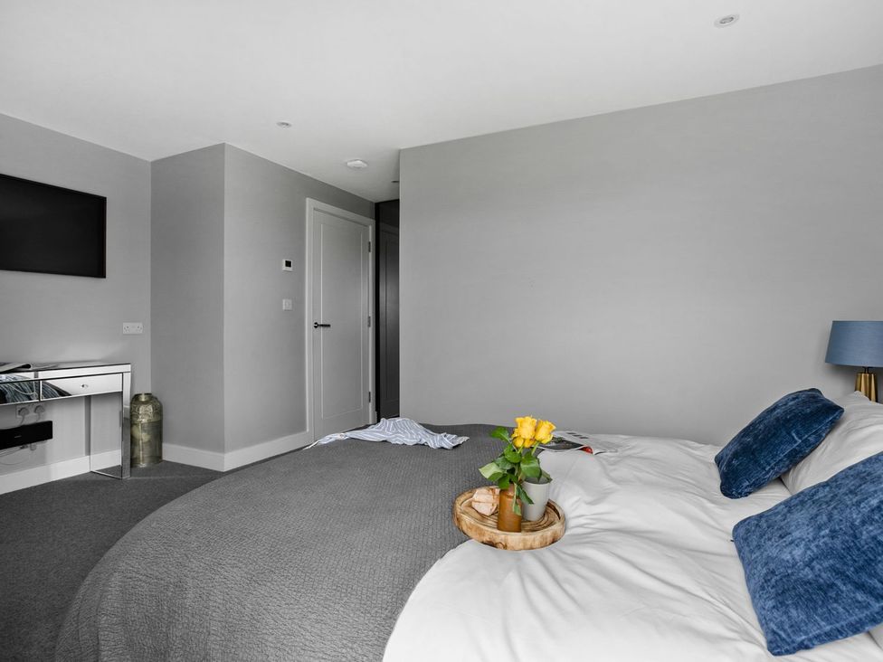A bedroom with a bed and a television at Huxham View & Annex in Kingsteignton