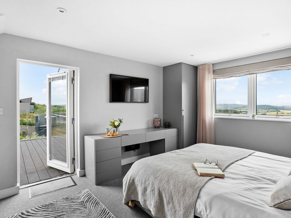 A bedroom with a bed and television at Huxham View & Annex in Kingsteignton