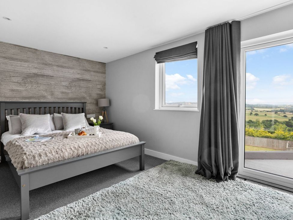 A bedroom with a bed and window at Huxham View & Annex in Kingsteignton