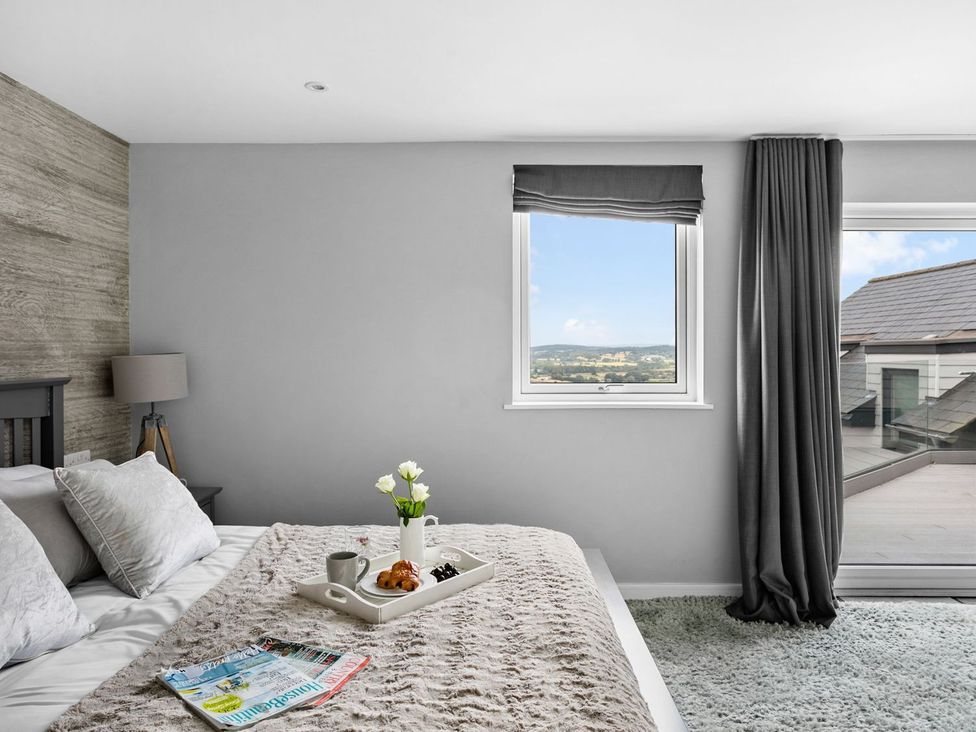 A bedroom with a tray on the bed at Huxham View & Annex in Kingsteignton