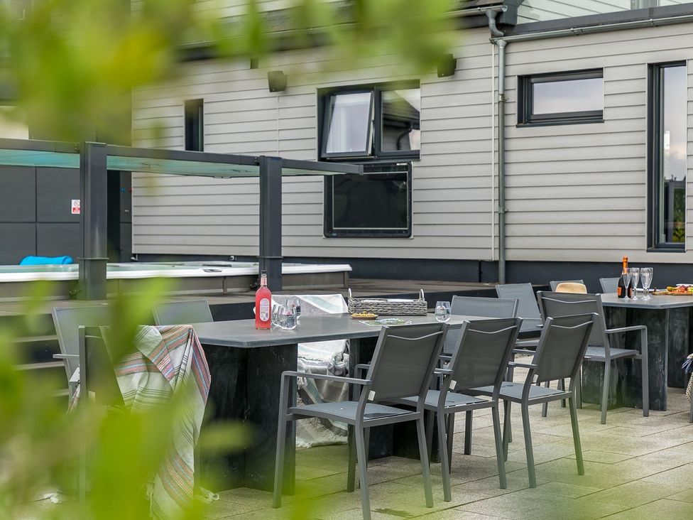 An outdoor seating area with a table and chairs at Huxham View & Annex in Kingsteignton