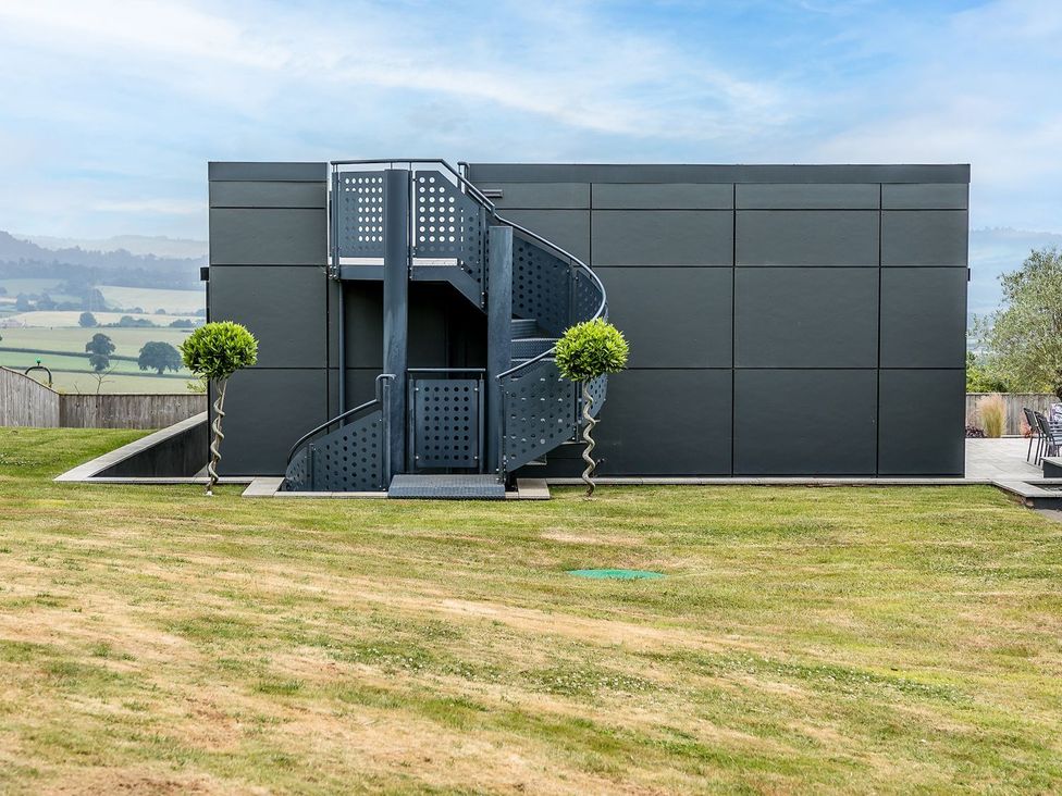 A building with a staircase in the garden at Huxham View & Annex Kingsteignton