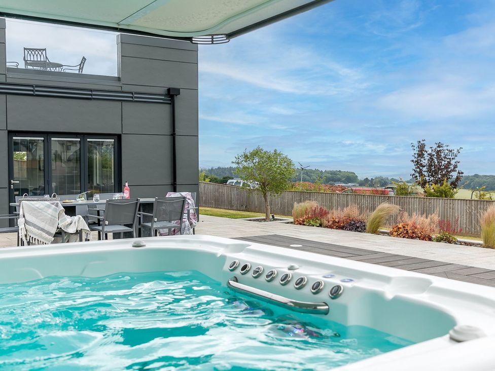 A hot tub with outdoor furniture in the garden at Huxham View & Annex in Kingsteignton