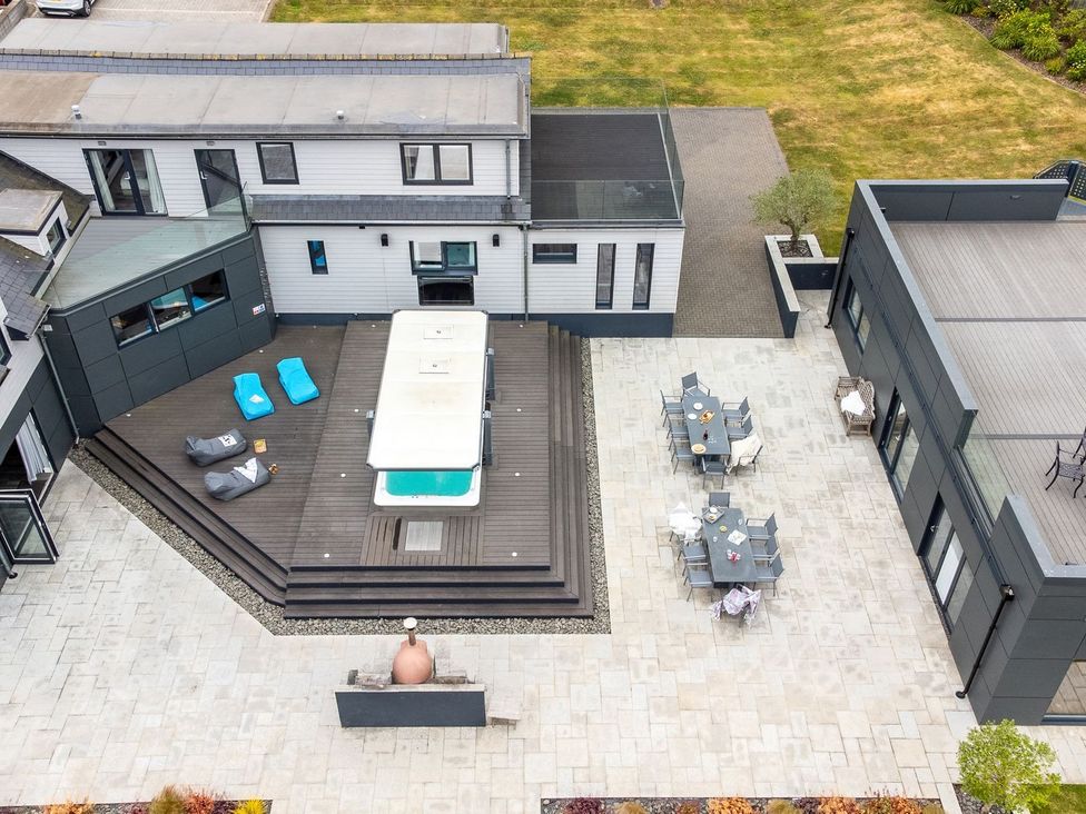 A patio area with hot tub and outdoor furniture at Huxham View & Annex in Kingsteignton