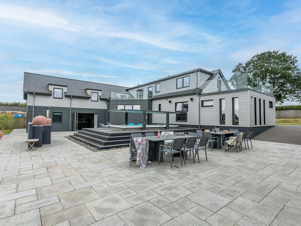An outdoor patio with a dining table and chairs at Huxham View & Annex in Kingsteignton