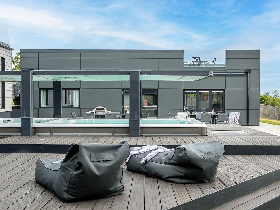 An outdoor area with a swimming pool and seating at Huxham View & Annex in Kingsteignton