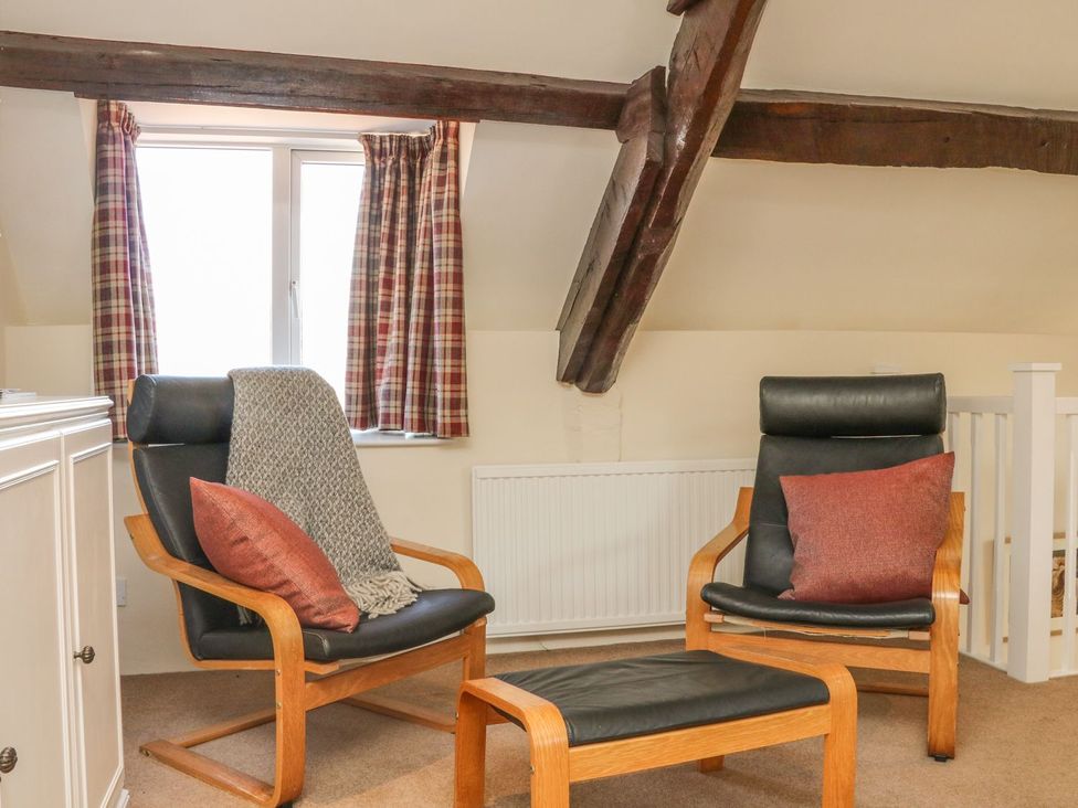 A sitting room with two chairs and a window at Upper Barn Cottage Minehead