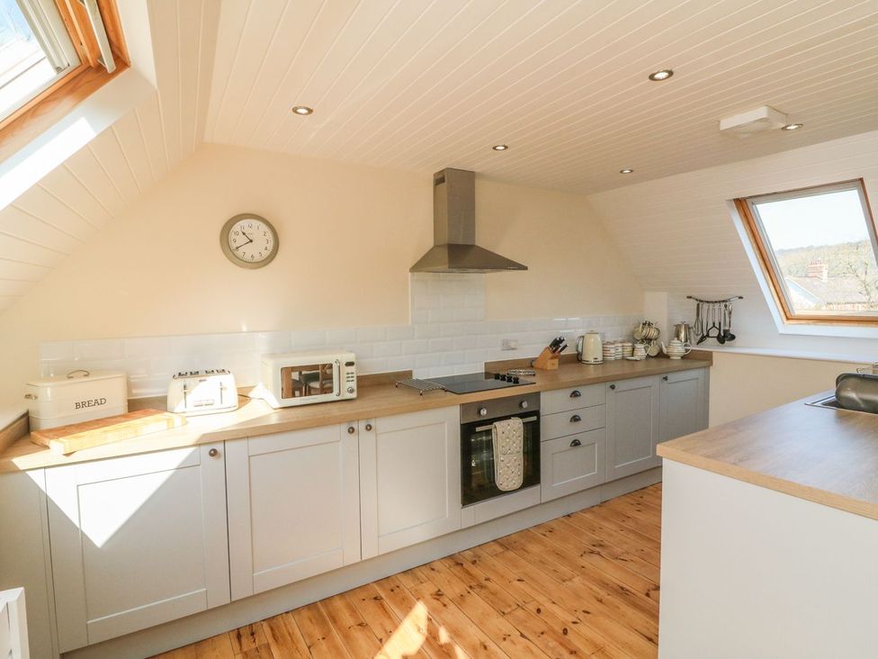 A kitchen with cabinets and appliances at Upper Barn Cottage Minehead