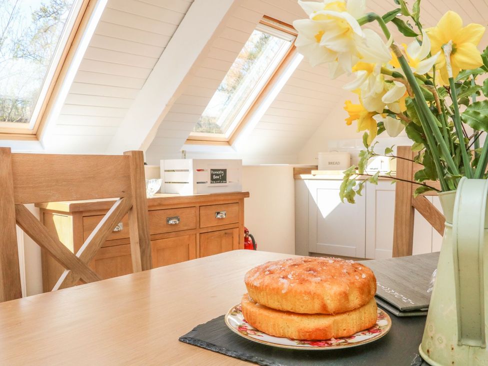 A kitchen with a cake on a table at Upper Barn Cottage Minehead