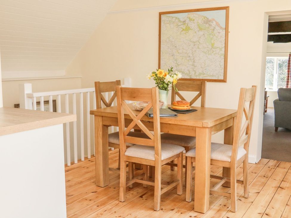 A dining area with a table and chairs at Upper Barn Cottage Minehead