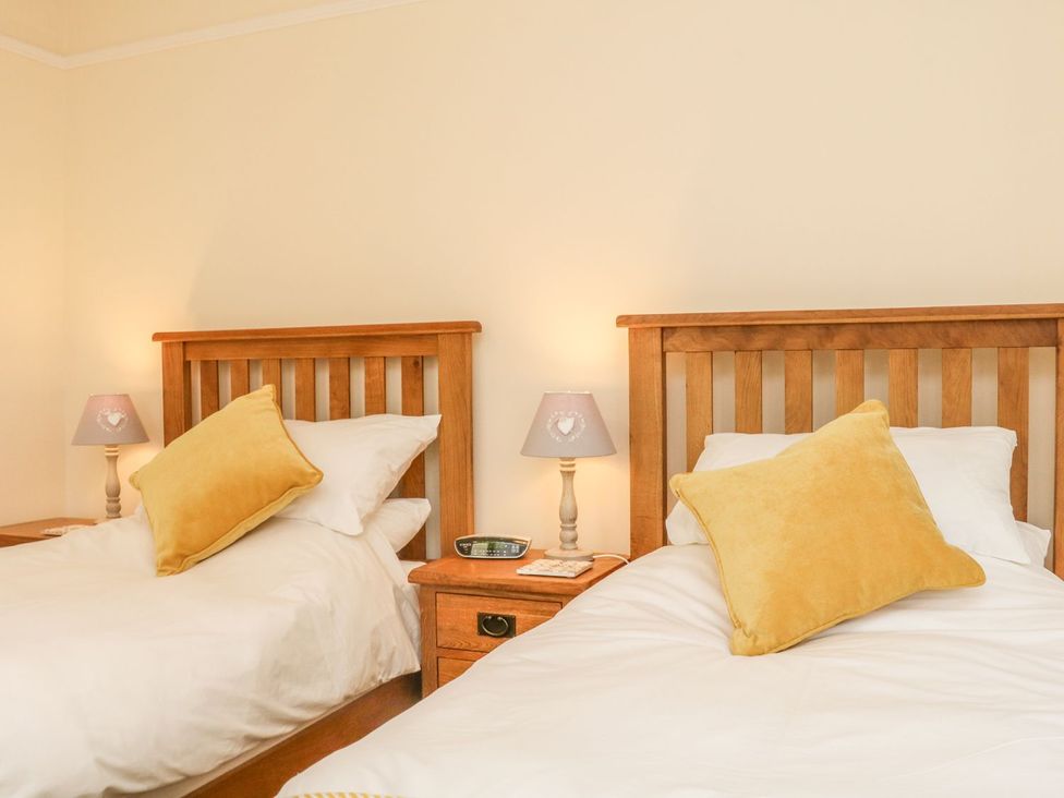 A bedroom with two single beds at Upper Barn Cottage in Minehead