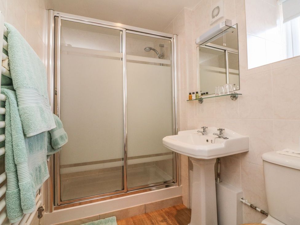 A bathroom with shower, sink, and toilet at Upper Barn Cottage Minehead