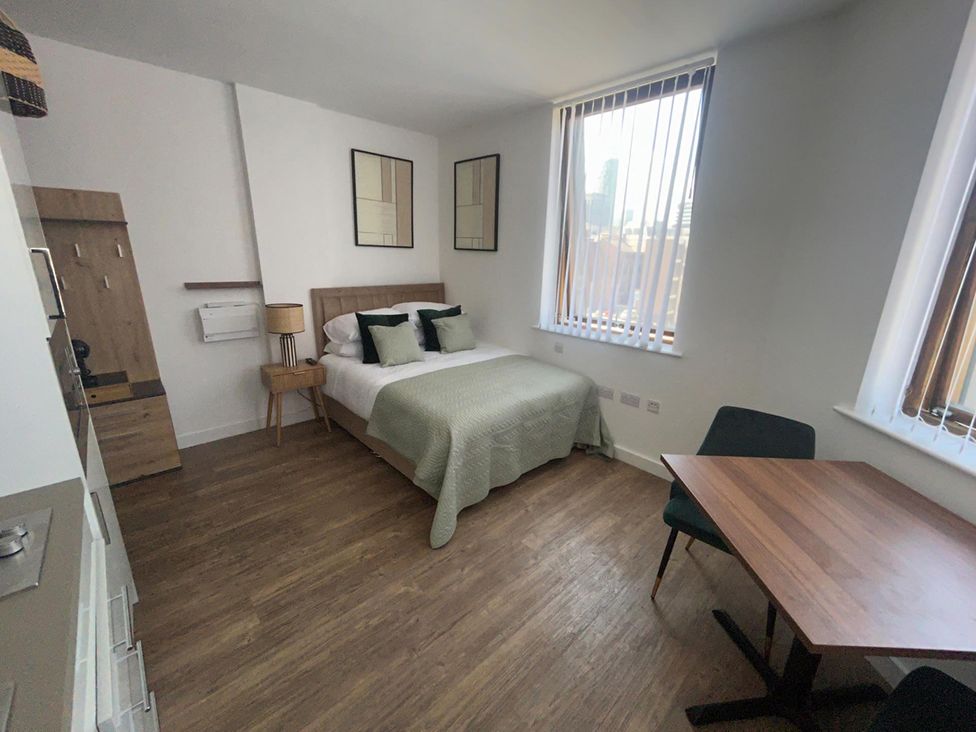 A studio room with bed and table at 1 Bed Studio, Sleeps 2 with City Views in Liverpool