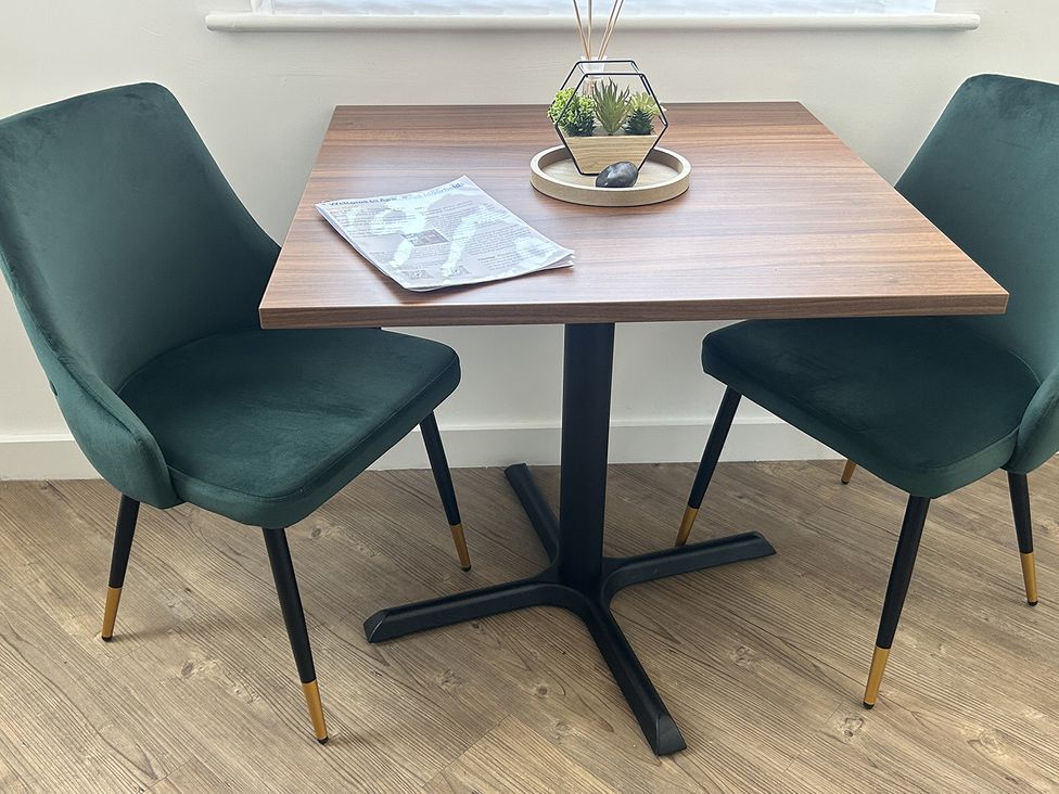 A dining table with two chairs and a plant at 1 Bed Studio, Sleeps 2 with City Views, Liverpool