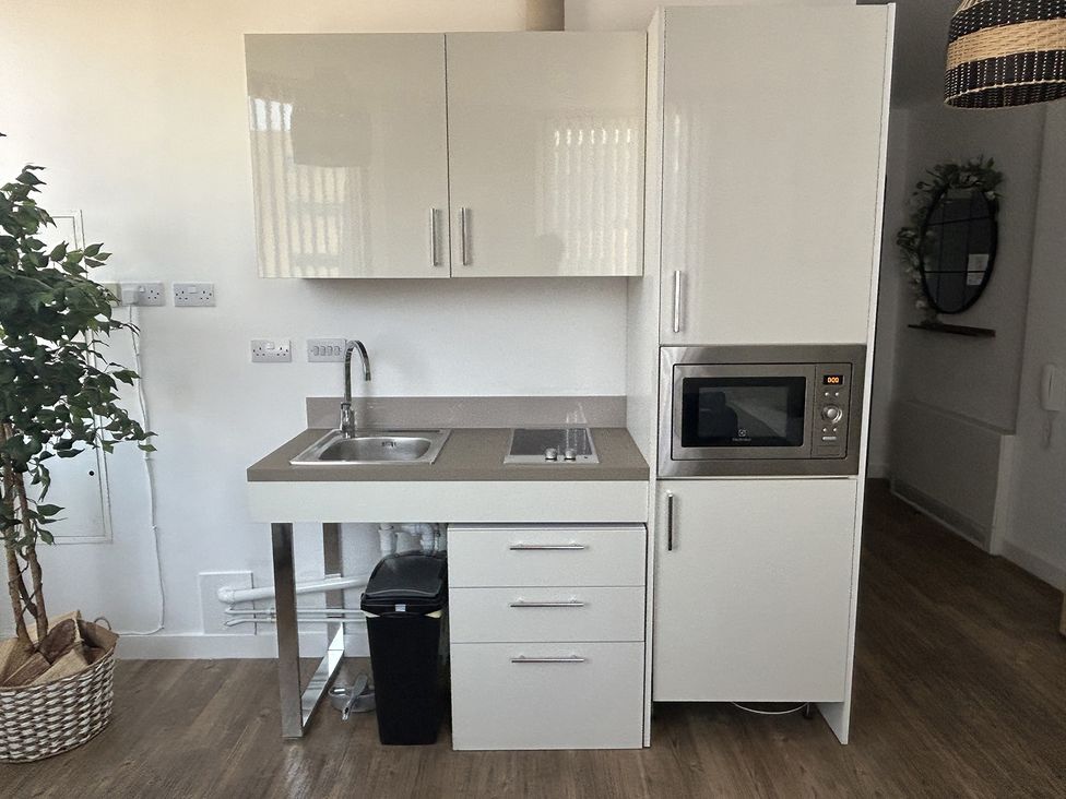 A kitchen with a sink, microwave, and refrigerator at 1 Bed Studio, Sleeps 2 with City Views, Liverpool