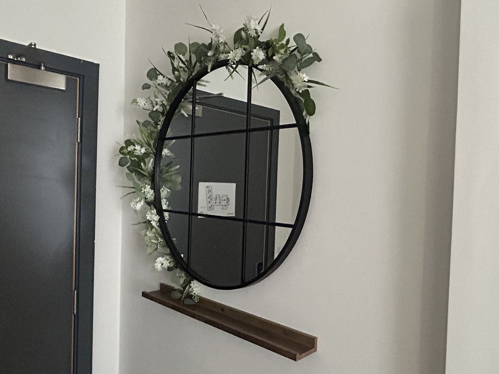 A mirror with a shelf in a hallway at 1 Bed Studio, Sleeps 2 with City Views, Liverpool