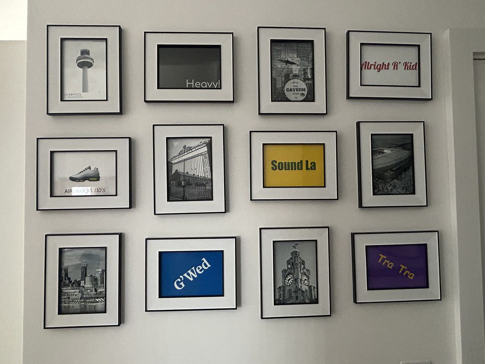 A collection of framed pictures on a wall at 1 Bed Studio, Sleeps 2 with City Views, Liverpool