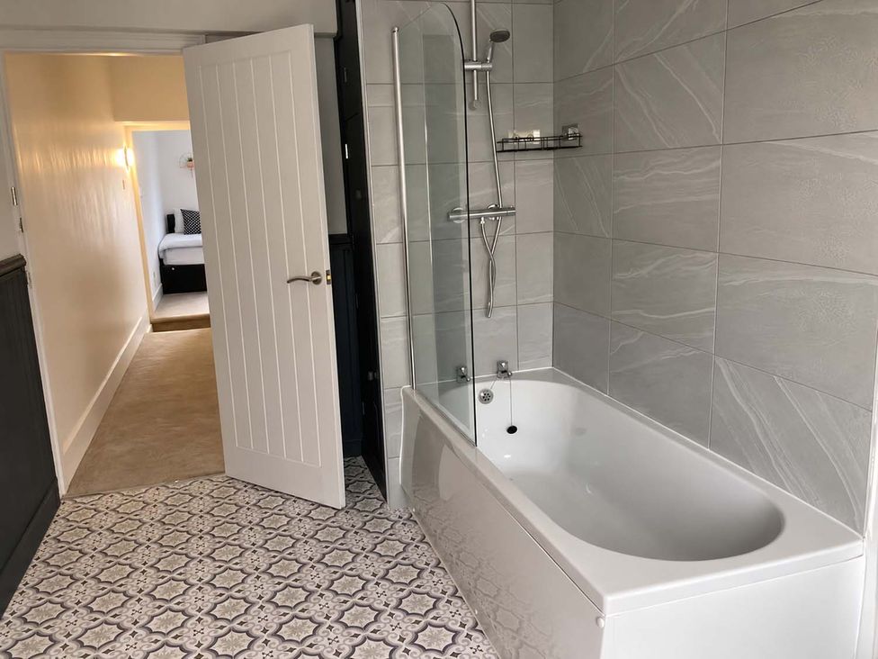 A bathroom with a bathtub and shower at 2 Bed House in Creswell, Sleeps 7 with Street Parking