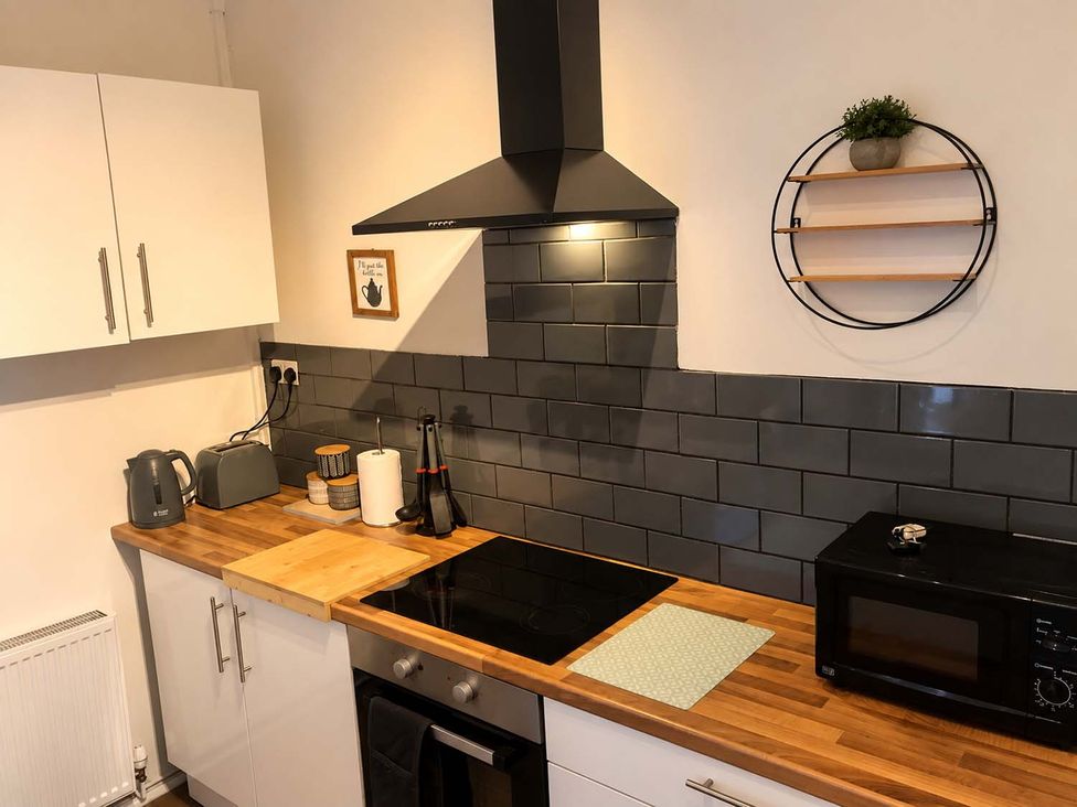 A kitchen with an induction cooktop and microwave at 2 Bed House in Creswell