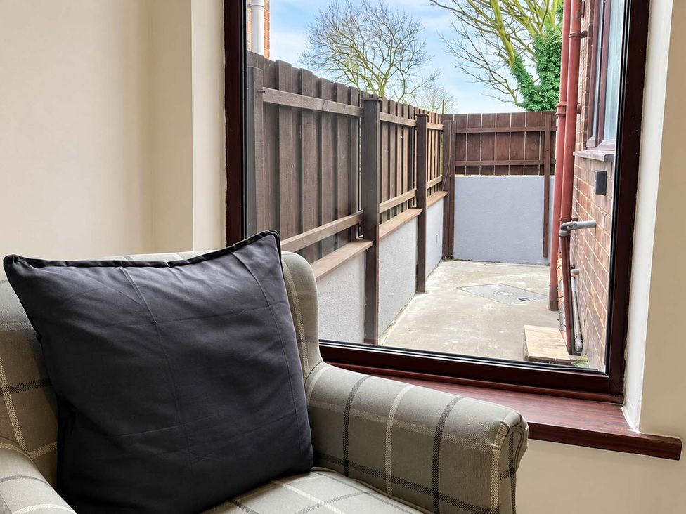 A chair with a cushion and a view of a fenced patio at 2 Bed House in Creswell, Sleeps 7 with Street Parking, Creswell