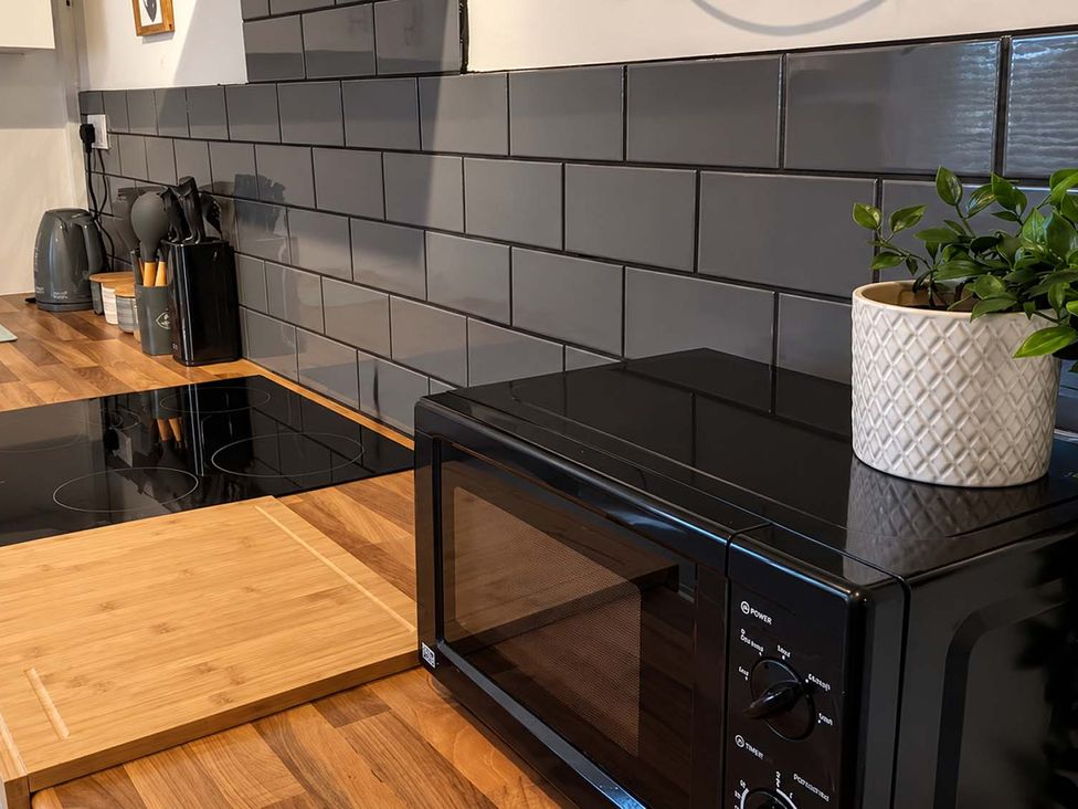A kitchen with a microwave and induction cooktop at 2 Bed House in Creswell, Sleeps 7 with Street Parking, Creswell