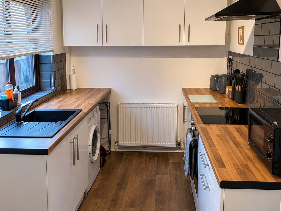 A kitchen with a sink and washing machine at 2 Bed House in Creswell, Sleeps 7 with Street Parking, Creswell