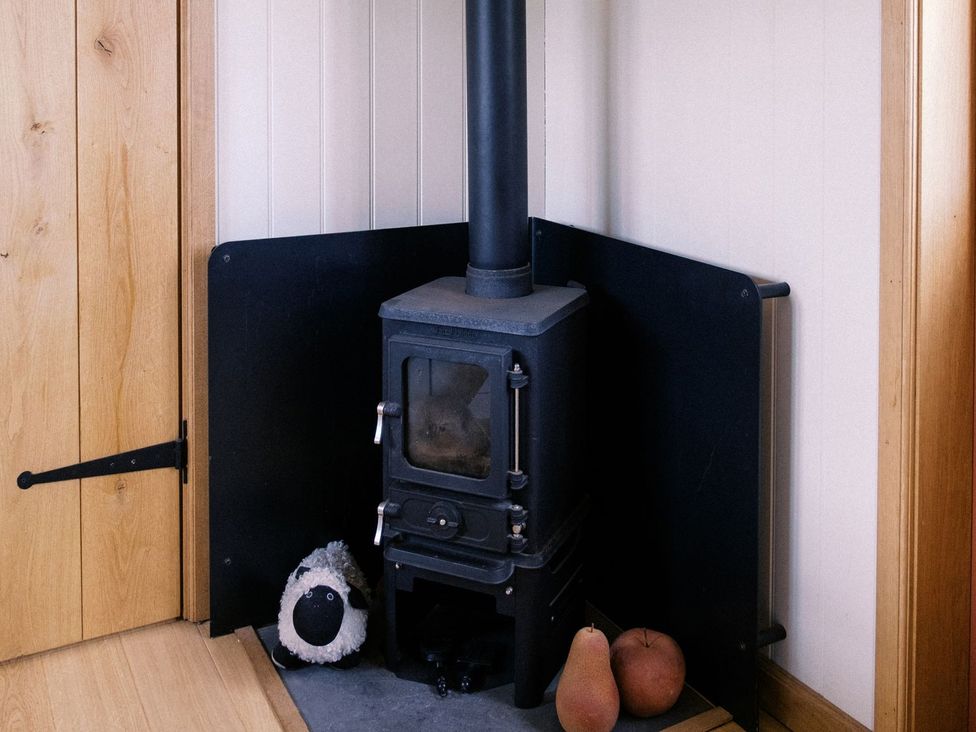 A stove with a plush toy and pears at Bonnie's Shepherds Hut at Shepherds Lodge Retreat and Wellness, Nottingham