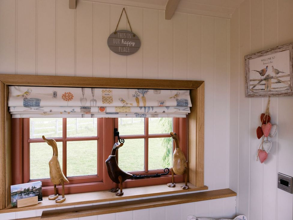 A window with decorative figurines and wall art at Bonnie's Shepherds Hut at Shepherds Lodge Retreat and Wellness, Nottingham
