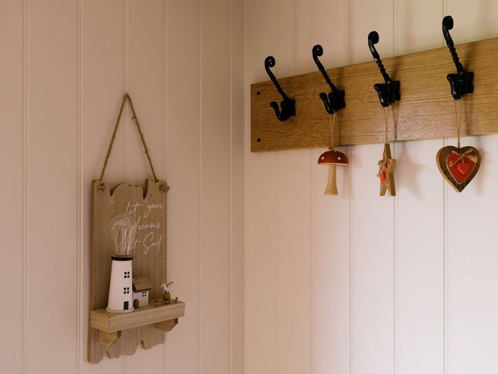 A hallway with coat hooks and decorative items at Bonnie's Shepherds Hut at Shepherds Lodge Retreat and Wellness, Nottingham