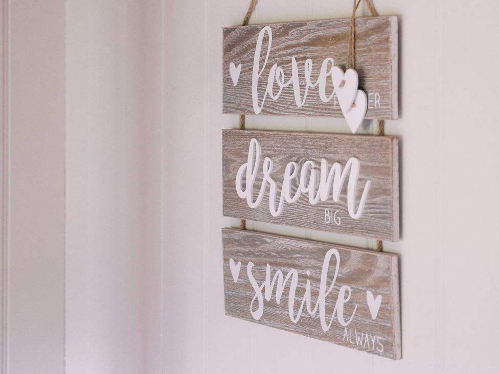 A wooden sign with text reading love dream smile at Bonnie's Shepherds Hut at Shepherds Lodge Retreat and Wellness, Nottingham