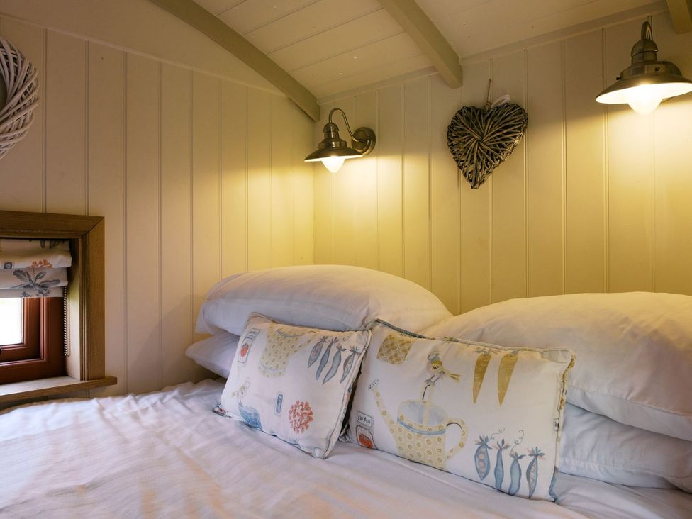 A bedroom with a bed and pillows at Bonnie's Shepherds Hut at Shepherds Lodge Retreat and Wellness Nottingham