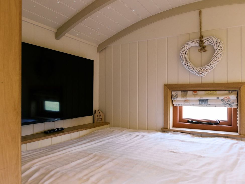 A bedroom with a television and a window at Bonnie's Shepherds Hut at Shepherds Lodge Retreat and Wellness Nottingham