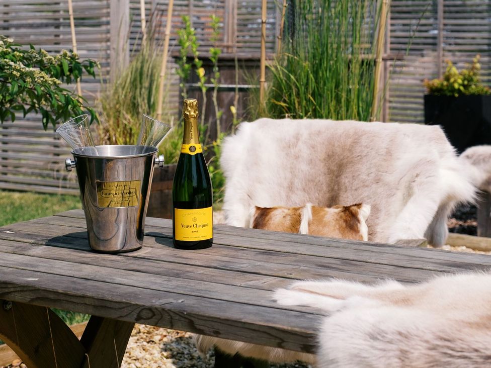 A wooden table with champagne and glasses at Bonnie's Shepherds Hut at Shepherds Lodge Retreat and Wellness Nottingham
