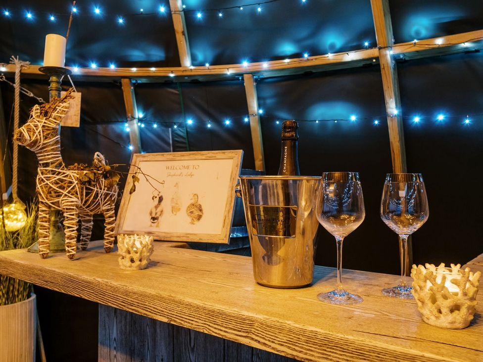 A bar counter with a champagne bottle and glassware at Bonnie's Shepherds Hut at Shepherds Lodge Retreat and Wellness Nottingham