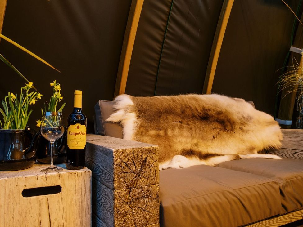 A cozy seating area with wine and flowers at Bonnie's Shepherds Hut at Shepherds Lodge Retreat and Wellness, Nottingham