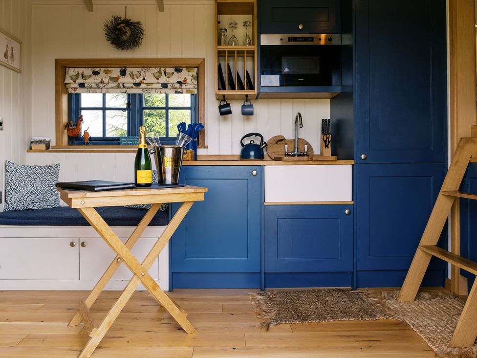 A kitchenette with sink and dining table at Lillie's Shepherds Hut at Shepherds Lodge Retreat and Wellness, Nottingham