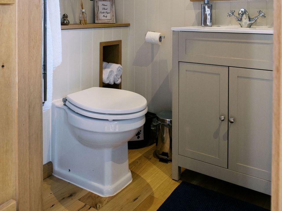 A bathroom with a toilet and sink at Lillie's Shepherds Hut at Shepherds Lodge Retreat and Wellness Nottingham
