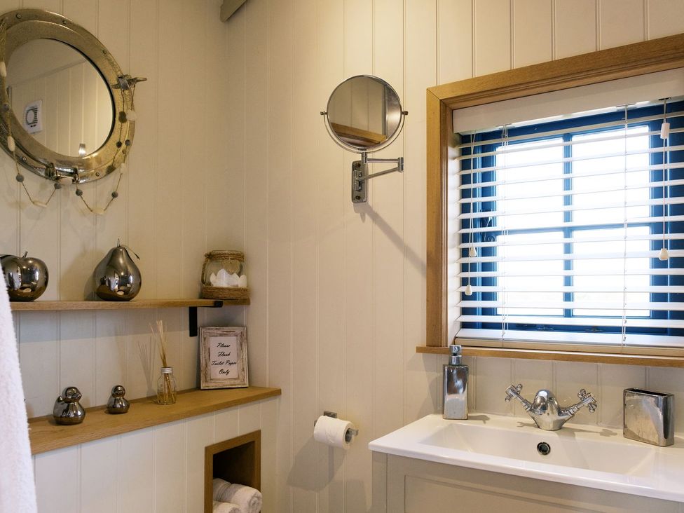 A bathroom with a mirror and sink at Lillie's Shepherds Hut at Shepherds Lodge Retreat and Wellness Nottingham
