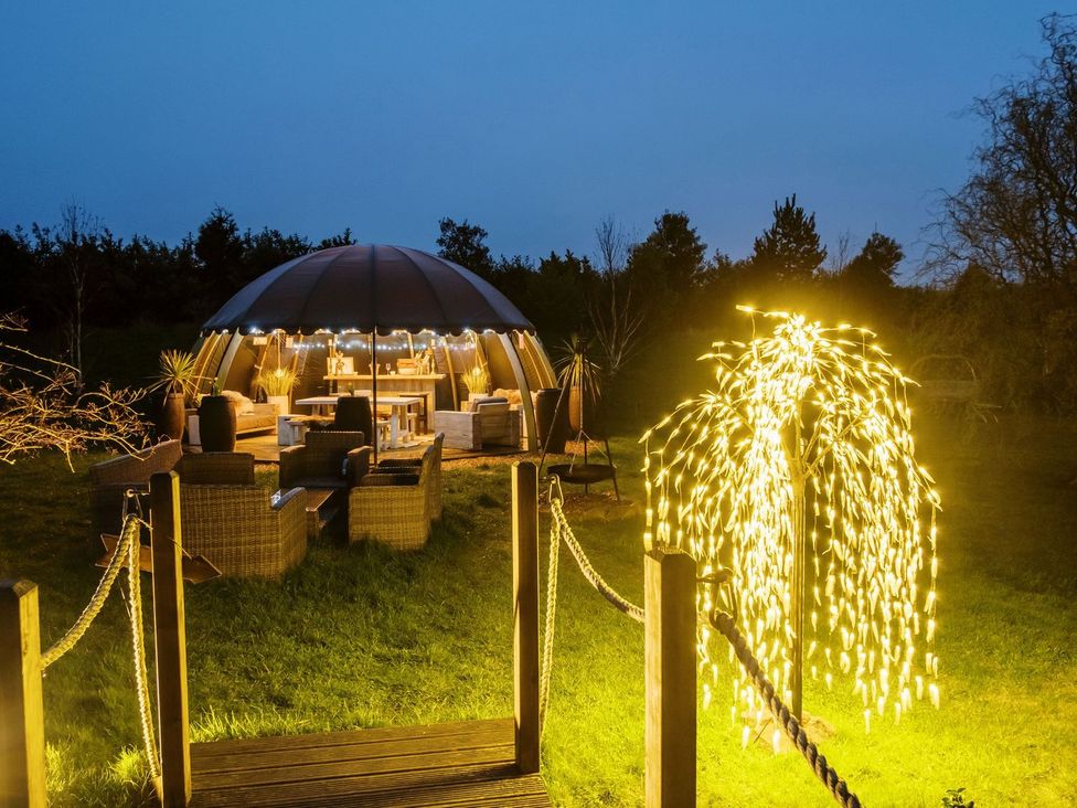 An outdoor seating area with a dome structure and decorative lights at Lillie's Shepherds Hut at Shepherds Lodge Retreat and Wellness Nottingham