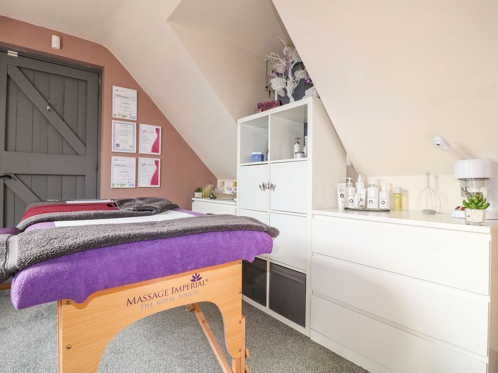 A treatment room with massage tables and skincare products at Lillie's Shepherds Hut at Shepherds Lodge Retreat and Wellness, Nottingham
