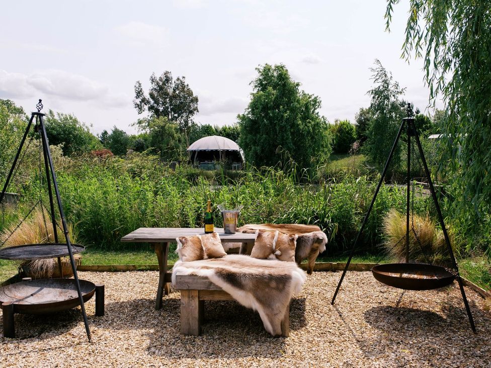 An outdoor area with a table and benches at Lillie's Shepherds Hut at Shepherds Lodge Retreat and Wellness Nottingham