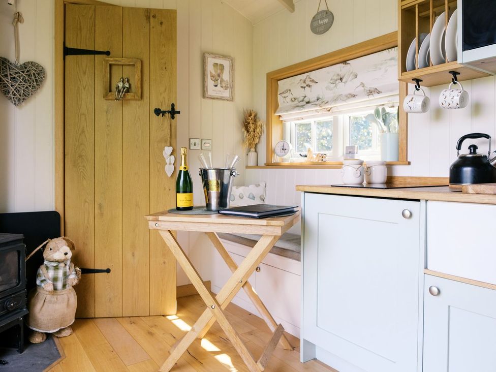 A kitchen with a table and chairs at Herbie's Shepherds Hut at Shepherds Lodge Retreat and Wellness Nottingham