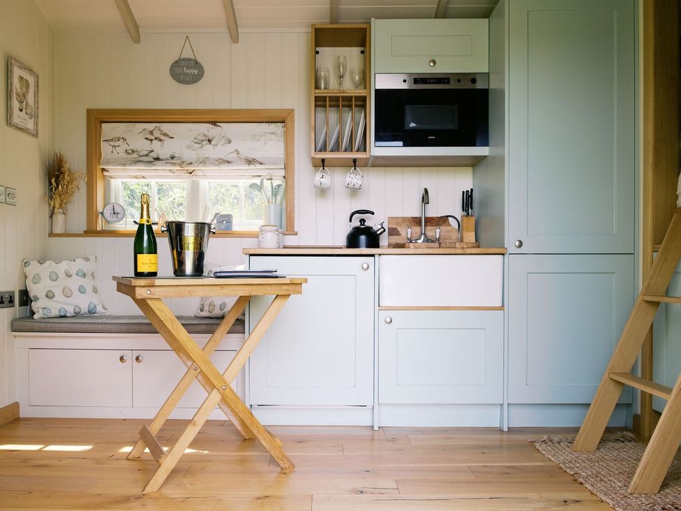 A kitchen with a table and champagne at Herbie's Shepherds Hut at Shepherds Lodge Retreat and Wellness Nottingham