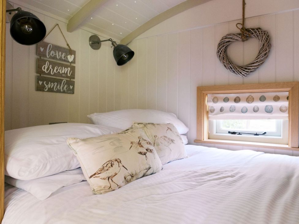 A bedroom with a bed and decorative items at Herbie's Shepherds Hut at Shepherds Lodge Retreat and Wellness Nottingham