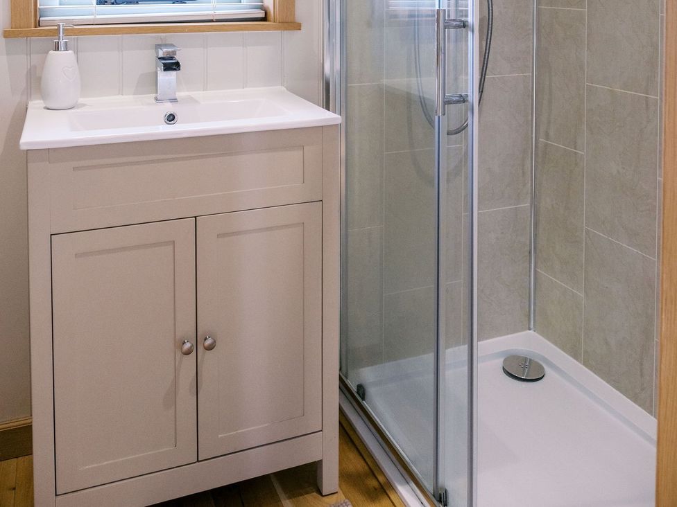 A bathroom with a sink and shower at Herbie's Shepherds Hut at Shepherds Lodge Retreat and Wellness, Nottingham