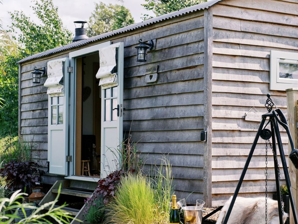 A shed with open doors and plants at Herbie's Shepherds Hut at Shepherds Lodge Retreat and Wellness Nottingham