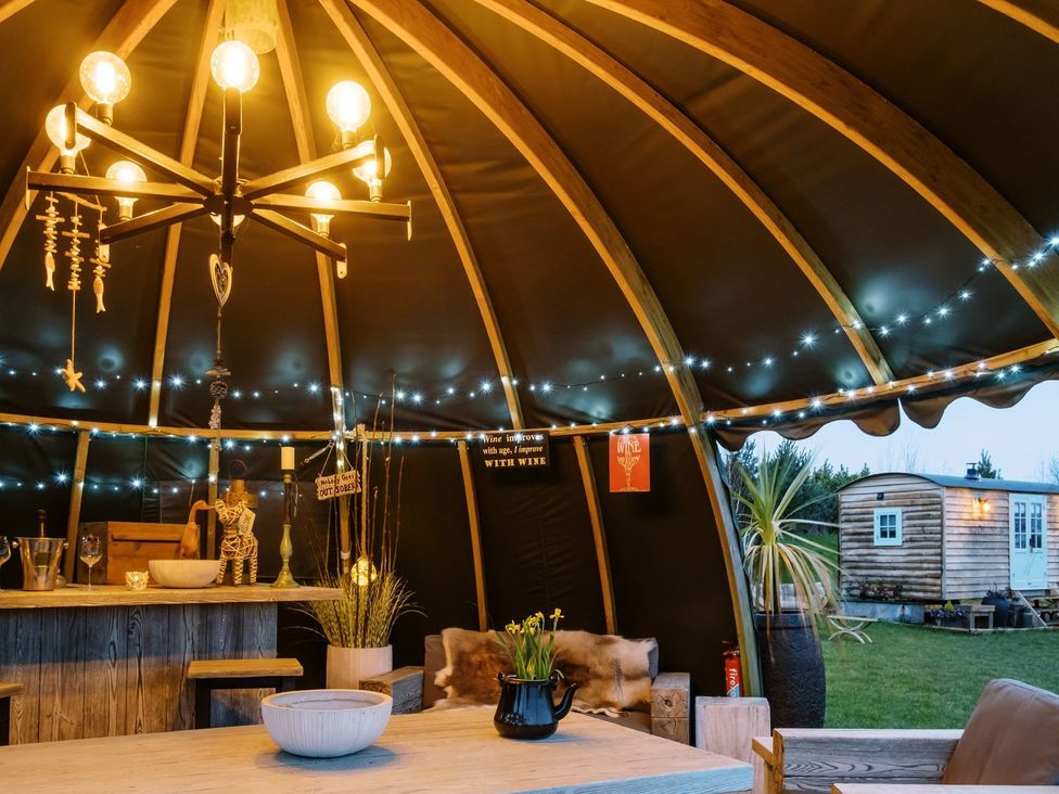 A gathering space with a bar and table at Herbie's Shepherds Hut at Shepherds Lodge Retreat and Wellness Nottingham