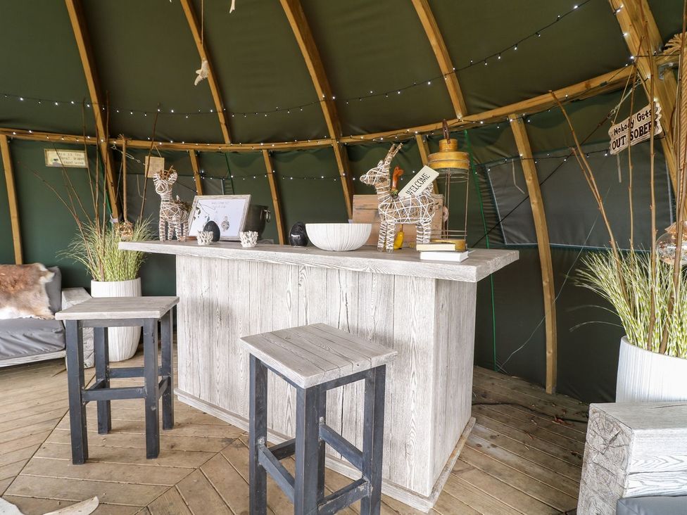 A bar area with stools and decorative items at Herbie's Shepherds Hut at Shepherds Lodge Retreat and Wellness Nottingham