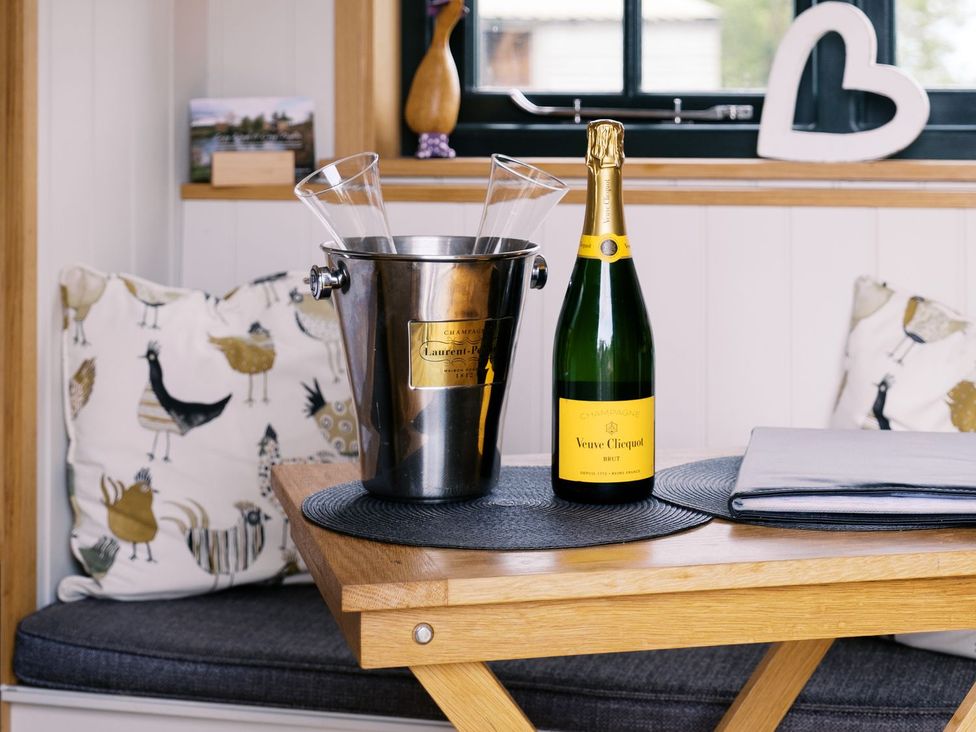 A snug area with a champagne bucket and glasses at Poppie's Shepherds Hut at Shepherds Lodge Retreat and Wellness in Nottingham