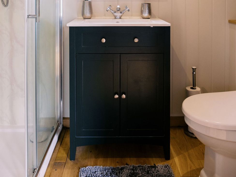 A sink and cabinet in a bathroom at Poppie's Shepherds Hut at Shepherds Lodge Retreat and Wellness Nottingham